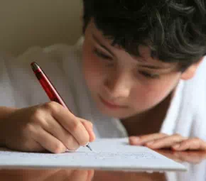 Chłopiec uczący się pisać